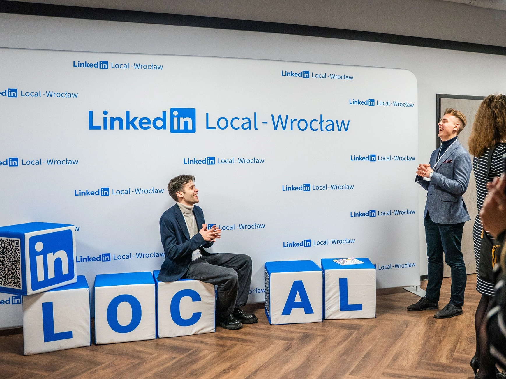Espace photo LinkedIn Local avec décor et cubes imprimés, où des participants échangent en souriant.