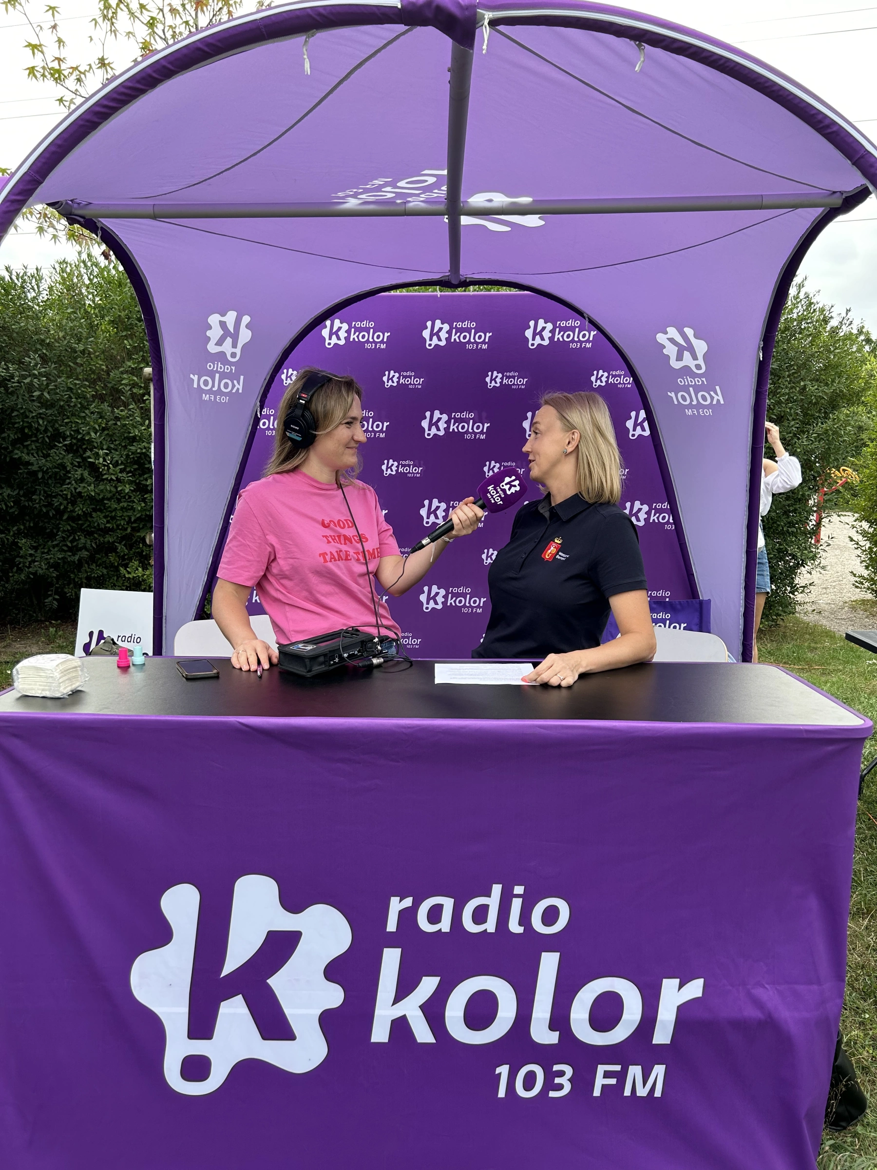 Audycja radiowa przeprowadzana w plenerze pod namiotem reklamowym