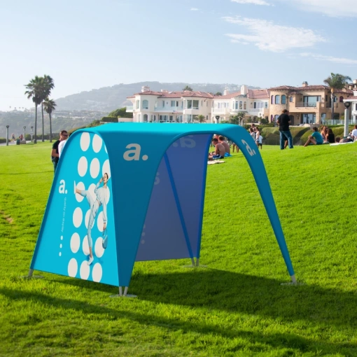 Niebieski namiot reklamowy vario adsystem ustawiony na trawie w parku