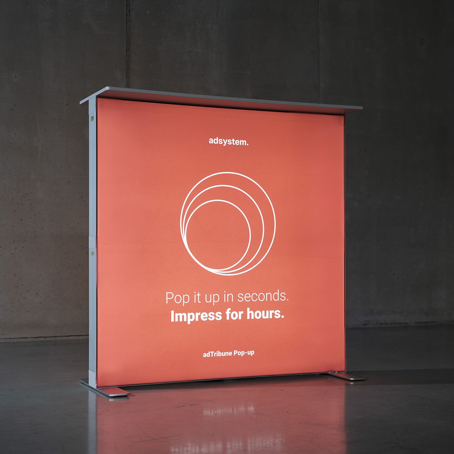 Podświetlana trybunka z wymienną grafiką prezentująca system adTribune Pop-up jako przykład materiału do wielokrotnego użytku.