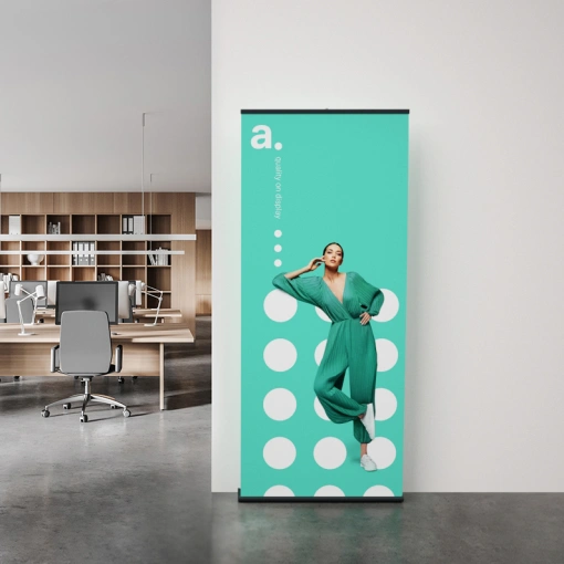 Roll-up ustawiony w nowoczesnym biurze – prezentuje nadruk promocyjny na tle w kolorze miętowym z graficznymi kropkami.