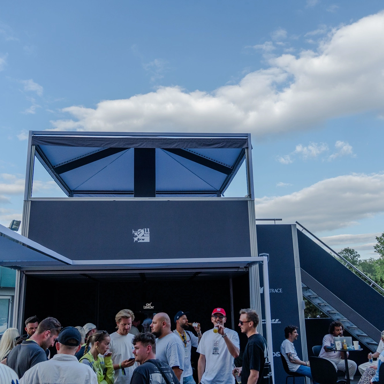 Dwupoziomowa strefa VIP z konstrukcji mFrame podczas Ultrace 2025, z zadaszeniem na górnym piętrze i uczestnikami eventu w strefie dolnej.