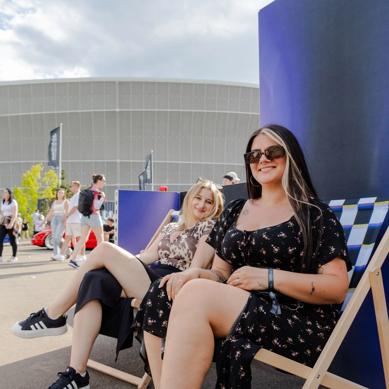 Dwie uczestniczki wydarzenia Ultrace 2025 relaksujące się na leżakach w strefie adsystem przed halą Areny Tarczyński.
