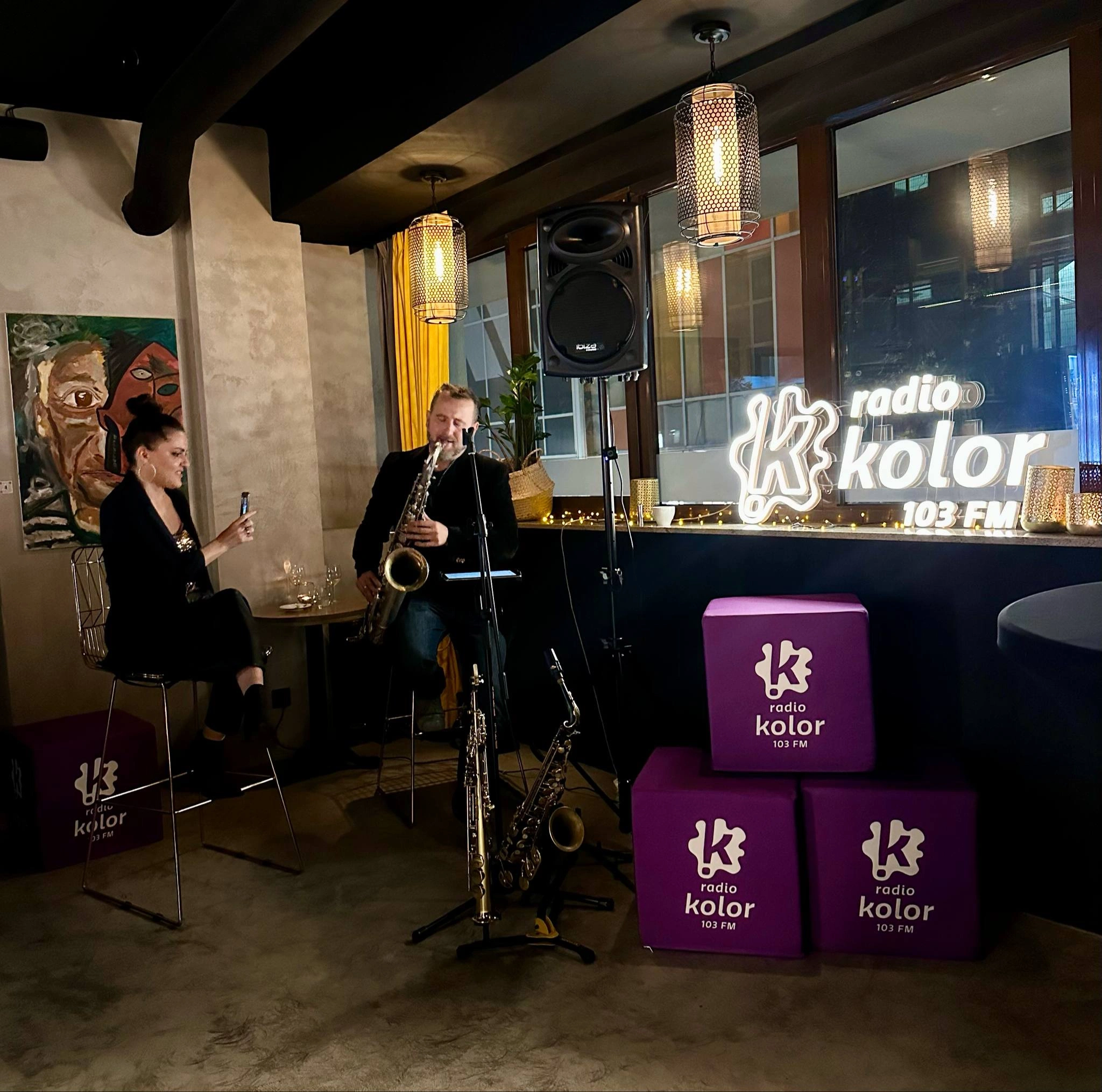 Pufy reklamowe we wnętrzu kawiarnii, w której odbywa się koncert na żywo.