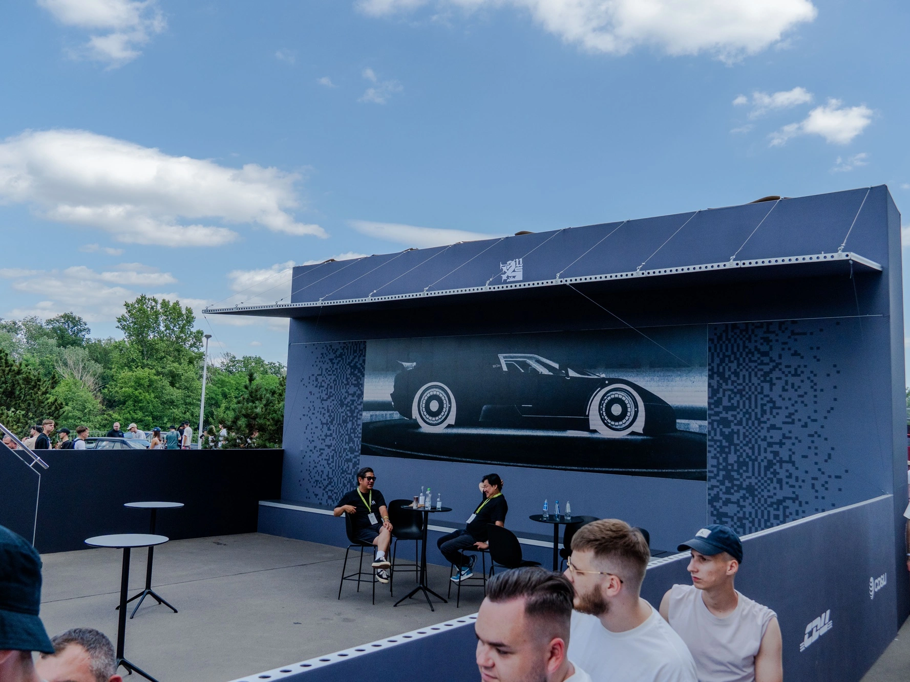 Dolny poziom strefy VIP na Ultrace 2025 z miejscami do siedzenia i grafiką samochodu na ścianie konstrukcji mFrame.